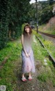 A woman standing on a train track in a black top and tulle skirt.