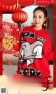 A woman in a red sweater holding a red lantern.