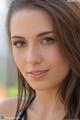 A beautiful young woman with long brown hair posing for a picture.