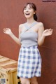 a woman in a blue and white checkered skirt posing for a picture