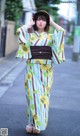 A woman in a kimono is standing on the street.